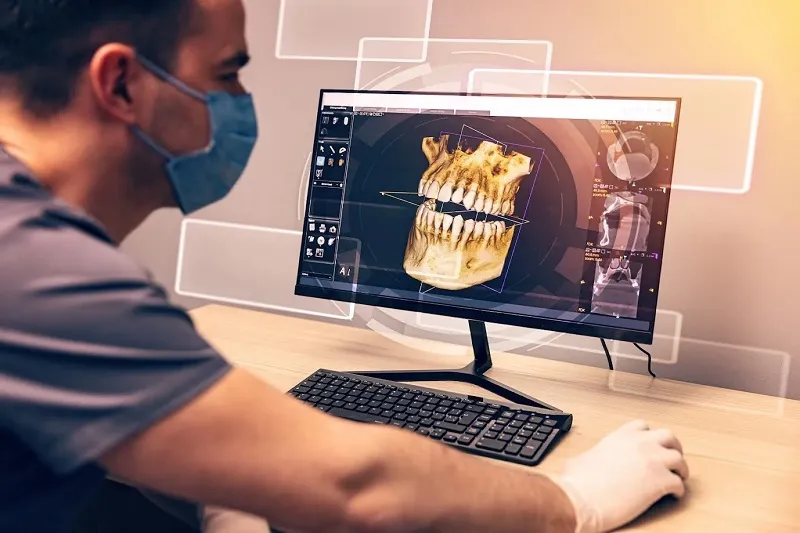 Staff member using software to look at a 3D image of a jaw