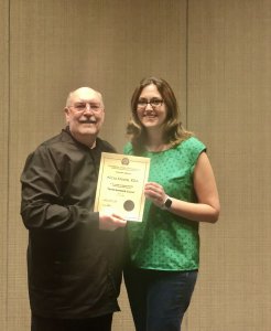 Staff member Alicia holding a Dental Assistant certificate