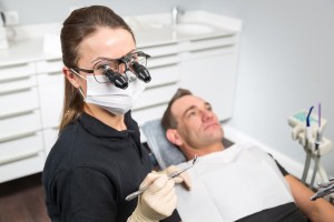 Staff member wearing glasses with high-power microscopes