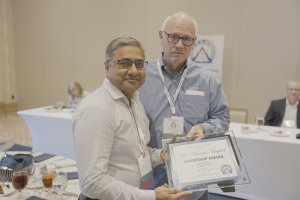 Dr. Mughal holding a Leadership Award